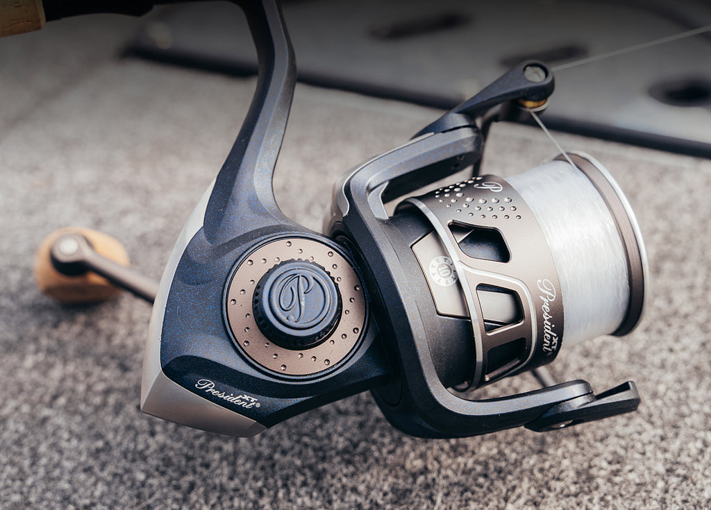 Close-up of a fishing reel on a textured surface