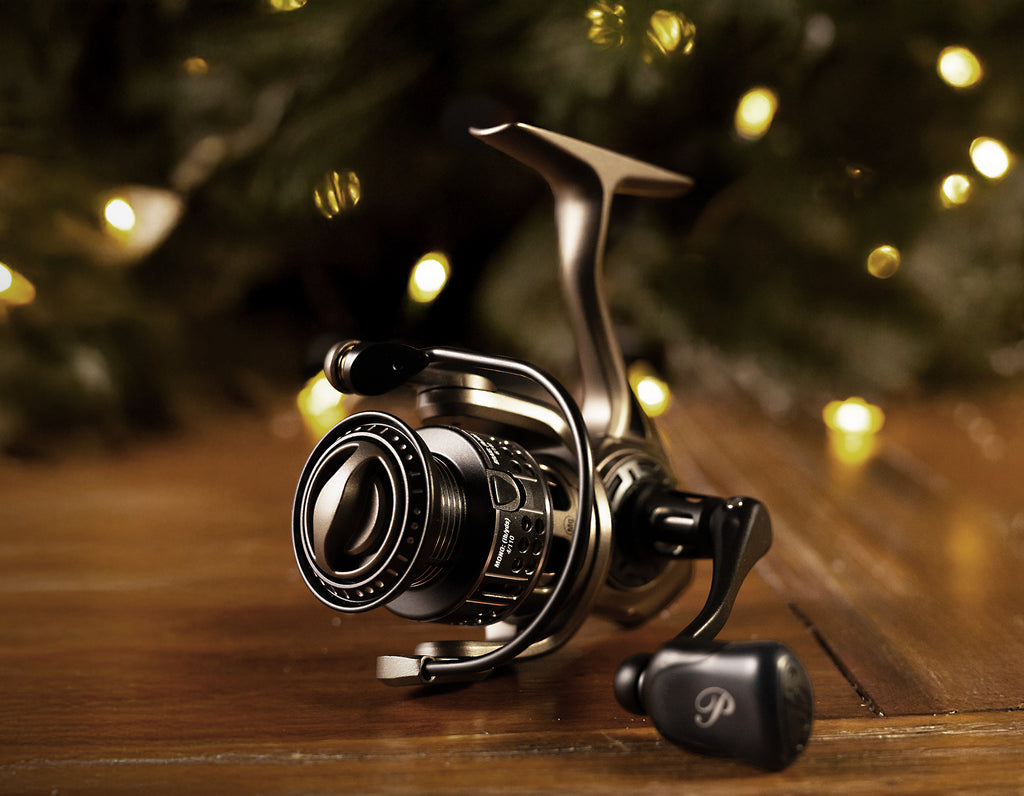 Fishing reel on a wooden surface with blurred lights in the background
