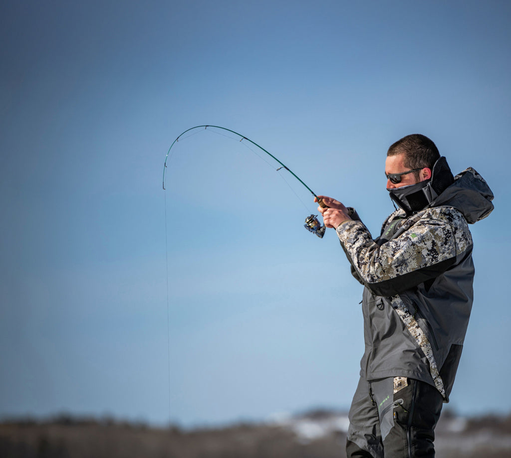 Person fishing with a fishing Combo against a clear blue sky